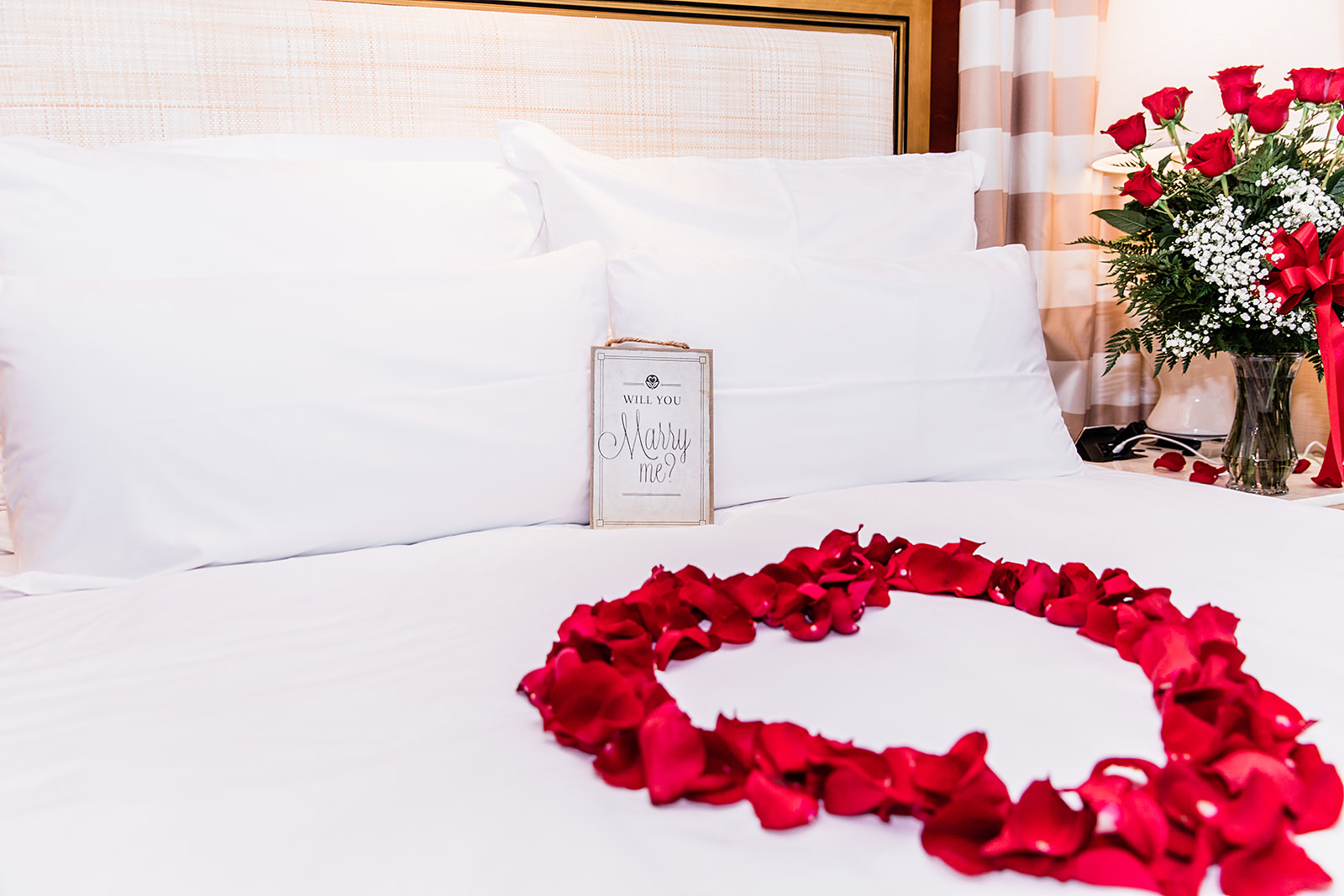 Las Vegas marriage proposal with roses arranged on bed
