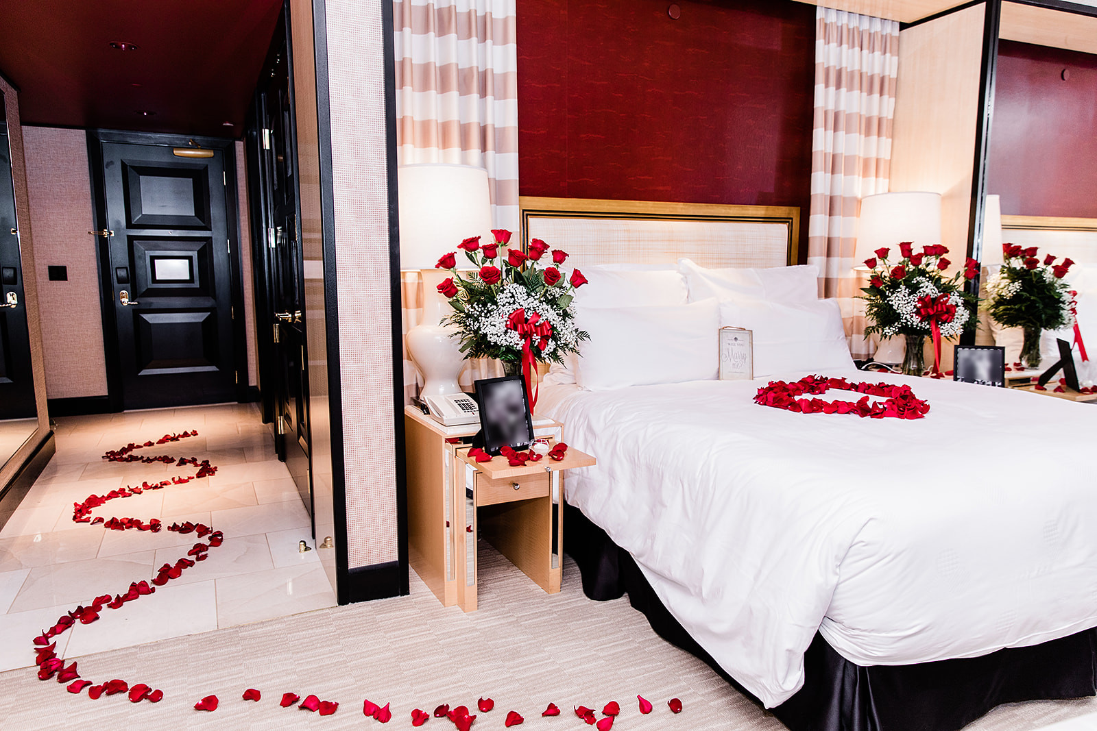 Vegas marriage proposal in hotel room with rose petals leading to bed with roses