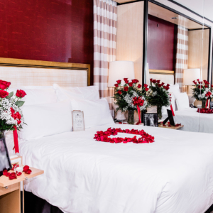 Roses arranged in hotel room for marriage proposal on bed