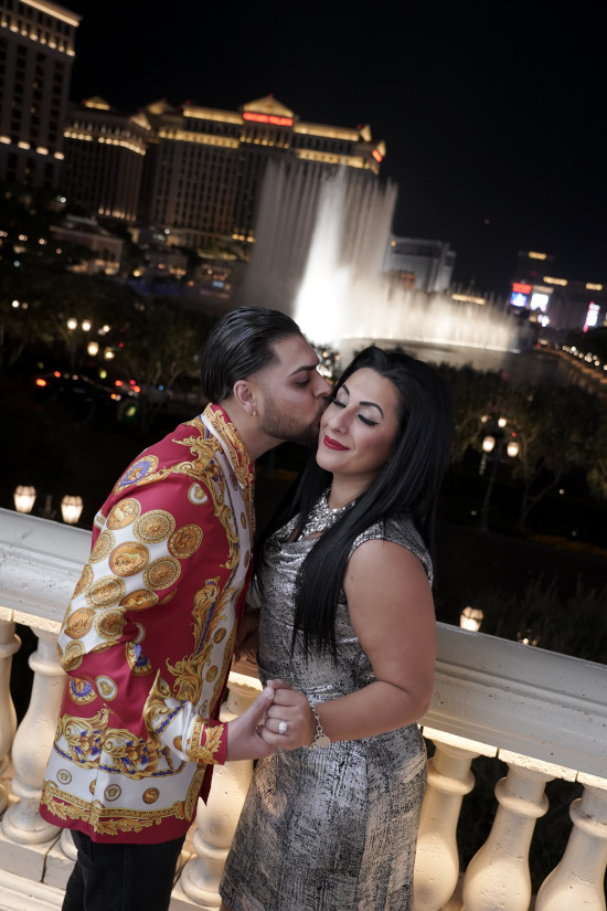 Man and woman pose with engagement ring at Las Vegas Bellagio fountains during proposal photo tour