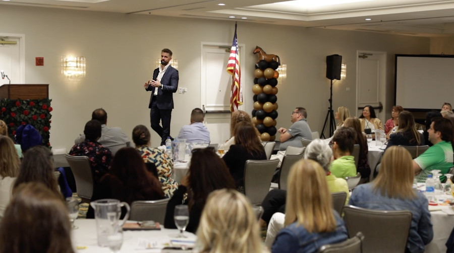 Keynote speaker Rob Anderson delivers a motivational speech at an association conference for an engaged audience.
