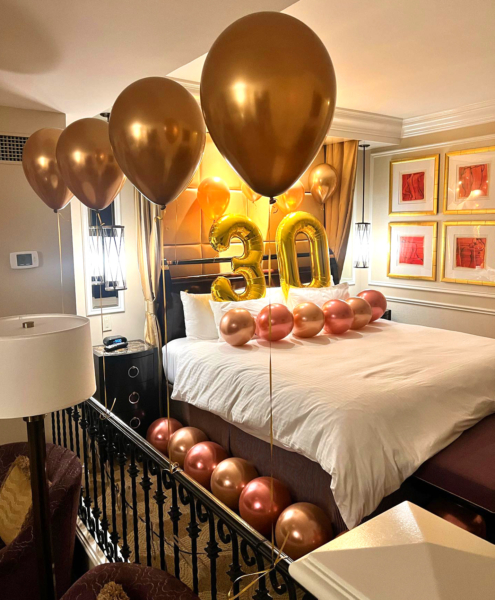 A room at the Venetian hotel in Las Vegas is decorated for a birthday celebration. Balloons are set up on and around the bed.